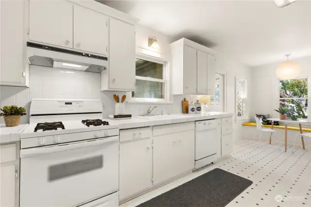 The eat-in kitchen features a gas range, oven, dishwasher, and refrigerator. A tiled backsplash reaches from the counter up to the cabinets.