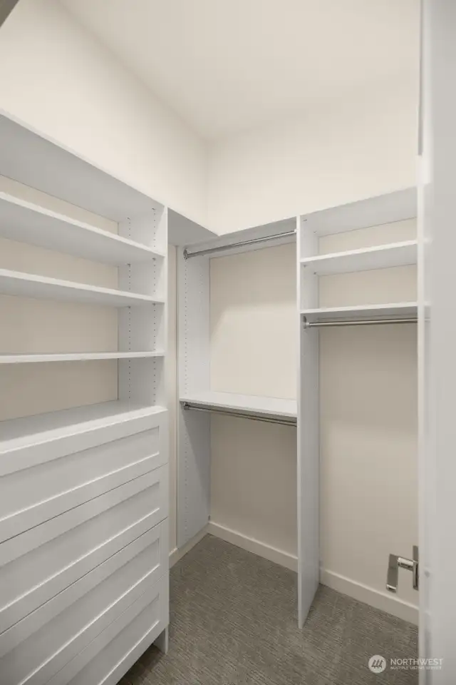 This thoughtfully designed walk-in closet offers ample shelving and hanging space to keep your wardrobe organized and accessible.