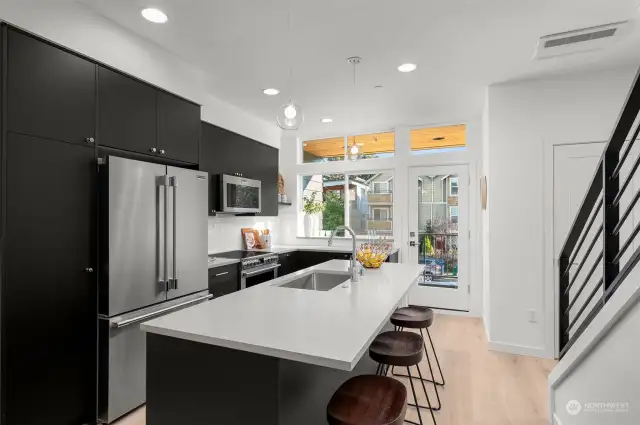 Step into your dream kitchen—a chef's delight featuring sleek black cabinetry, modern appliances, and a large island ready for prep or casual dining—the perfect combination of style and functionality.