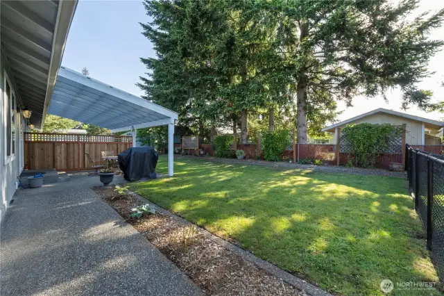 Raised garden beds and lush greenery throughout the property provide a peaceful outdoor retreat.