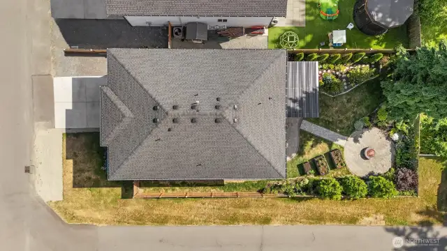Aerial view of home showcasing the private backyard with covered patio, custom landscaping and fire pit area.
