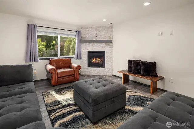Living room with large windows and gas fireplace.