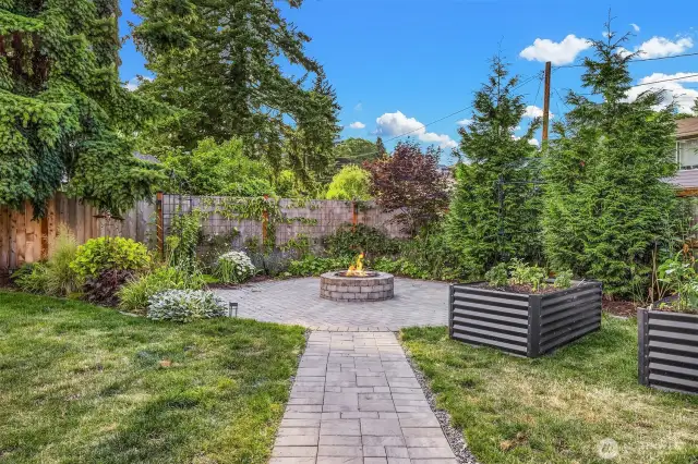 Paved fire pit area in backyard of home.