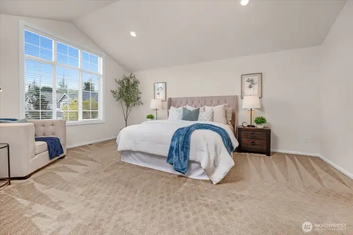 The primary suite is very spacious and features room for dressers and seating.