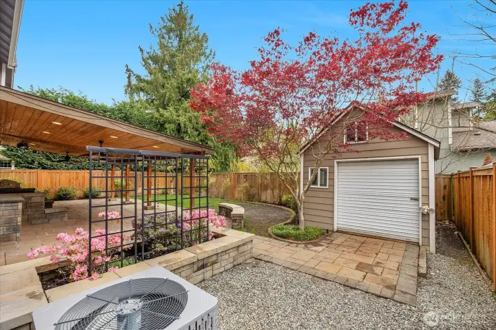 The backyard showcasing the shed, the AC and a view of the gorgeous plantings.