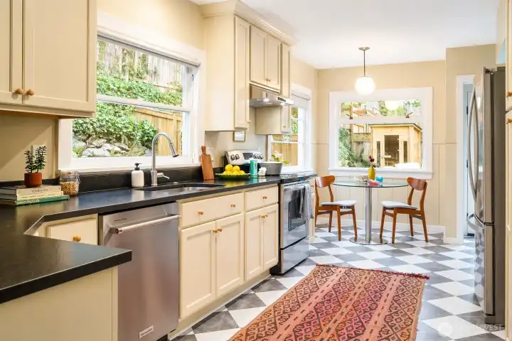 A charming kitchen with space for everything, stainless appliances, and bistro tile floors.  The sunny breakfast nook with garden views is a perfect spot to greet each day .