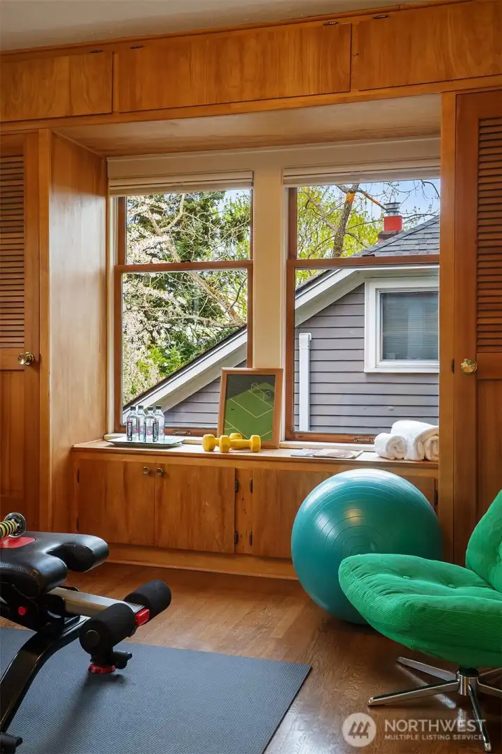 Stunning main floor bedroom with a cozy window seat is a perfect office, gym or guest space.