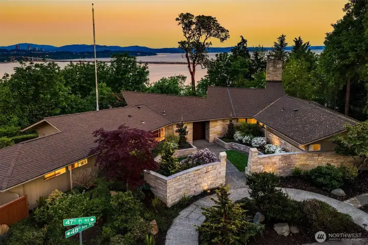 Arrival is deliberate. Curved stone walls guide the approach, iconic bowing columns mark the threshold, and the home reveals itself gradually — restrained, confident, and deeply grounded in its site.