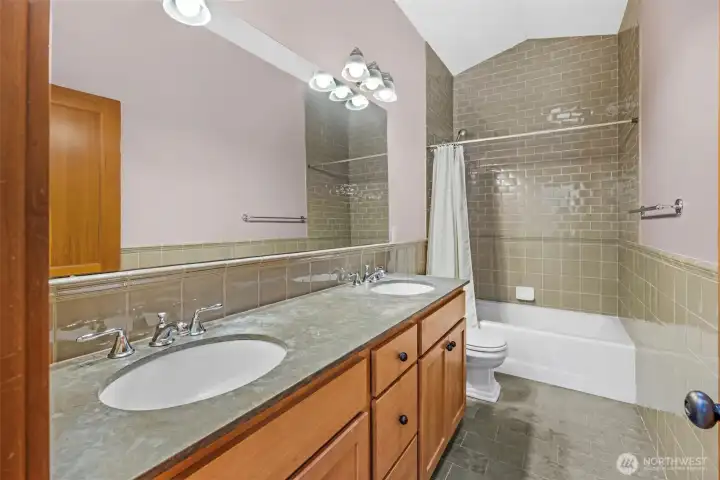 Shared full bathroom with long counter and 2 sinks
