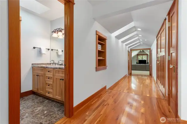 Upstairs hall to rec room has large storage areas on both sides