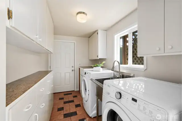 Main house laundry room with lots of storage and access to carport