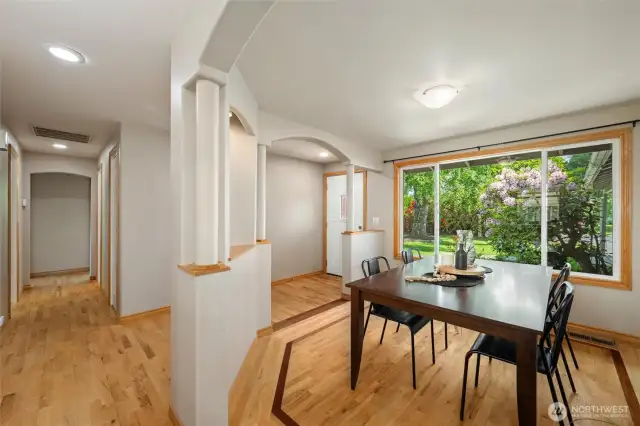 Main house dining room with custom hardwood flooring and views of the beautiful front yard private garden.