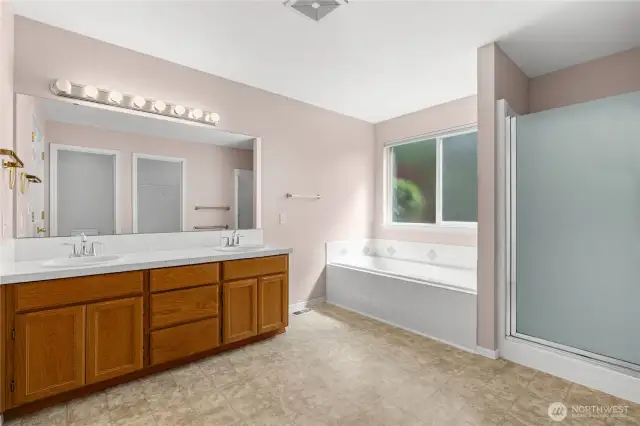 Primary 5-Piece En Suite Bath with extra long tiled vanity, soaking tub and separate shower.
