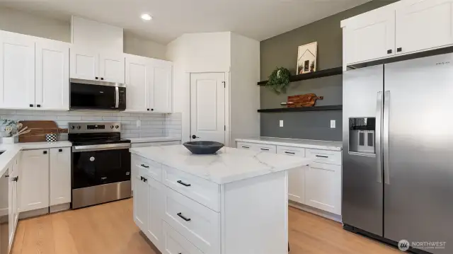 Kitchen appliances include fridge. Floating shelving is an added plus.