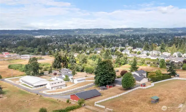 Overhead view of House & 2 garages on the right, red 10 car garage bottom middle, barn & equipment storage building towards the left & 60X120 covered arena on left with asphalt driveway. Top of picture on left is Tacoma & Edgewood @ top right. Valley in middle of picture with trees