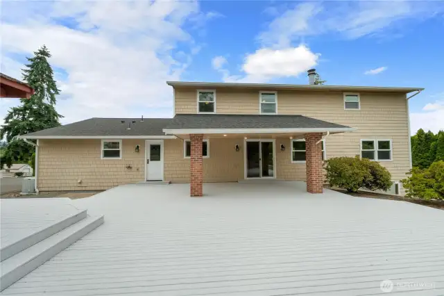 Back view of huge deck looking back to covered area leading into home through slider.