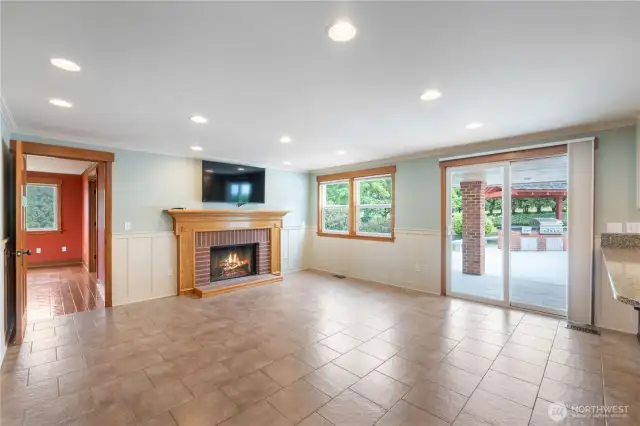 View looking a fireplace in the living room, family room door on the left & sliding door leading out to deck on the right