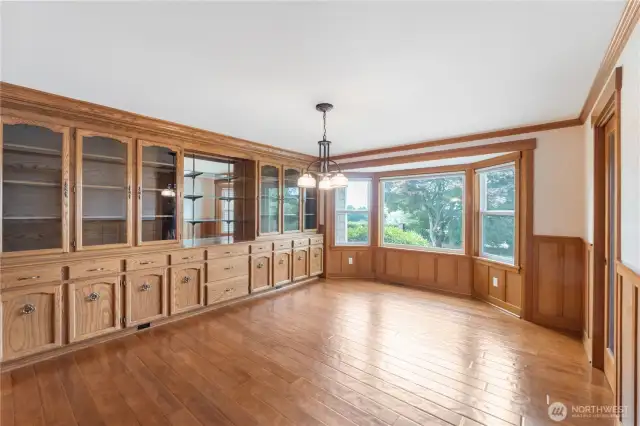 Dining room with amazing built in cabinets/glass doors/drawers/wood doors below.  Also has a hutch in the middle and wood floors accenting whole ambiance