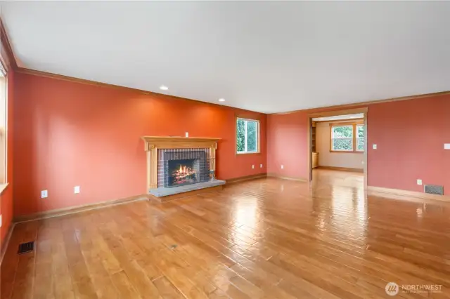 Large Family room with fireplace/mantle leading into office on the right. Far right has large TV that stays with home.