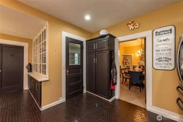 Door on the left side next to the wall of original built-in cabinetry leads you to a full bath. Middle door provides you access to laundry room, mud room and two car garage. Dining room showcased on the far right has a barn door.