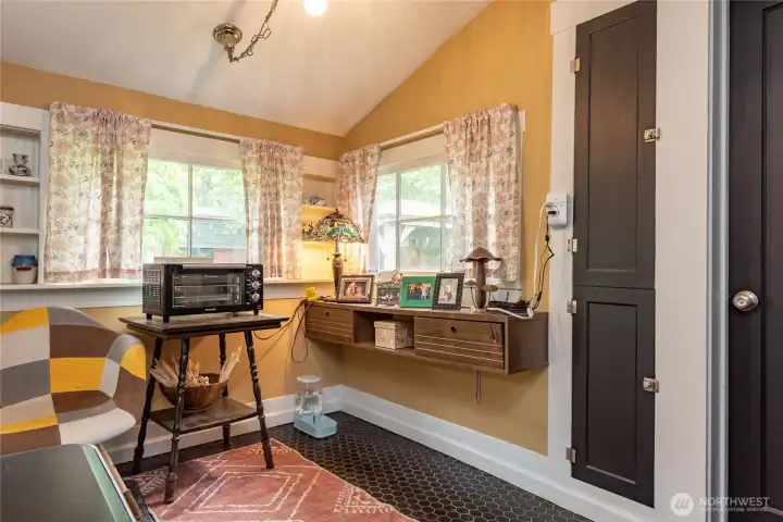 Breakfast nook currently being utilized as a relaxing seating area has an access door to the left to lead you to the backyard.