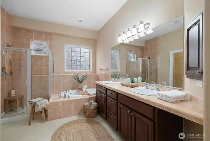 Bright and beautiful primary bedroom with abundant natural light, top-down/bottom-up blackout blinds, a full tile shower, marble tile double vanity, and a large walk-in closet.