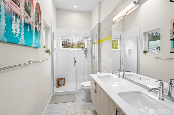 Primary bathroom on the top floor with 2 sinks and large windows that allow natural lighting