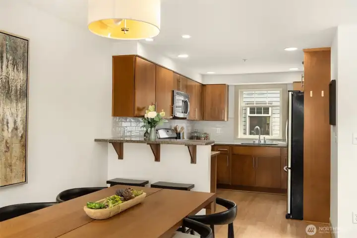 The dining area flows seamlessly into the kitchen, creating an inviting space for casual meals, holiday gatherings, and everyday connection.