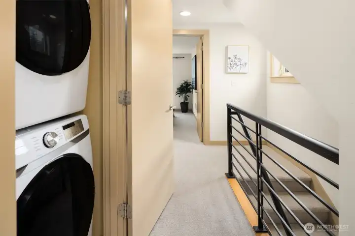 The secondary bedroom level is thoughtfully arranged with two bedrooms, a shared bath, and laundry—creating a practical and efficient living space.
