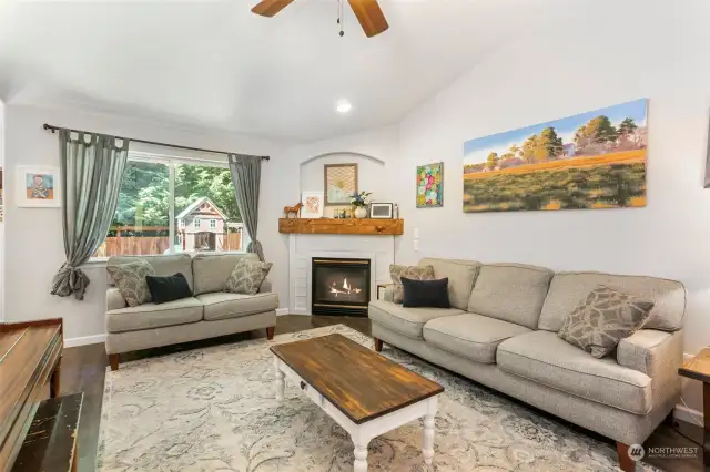 Living room with vaulted ceiling, ceiling fan and gas fireplace