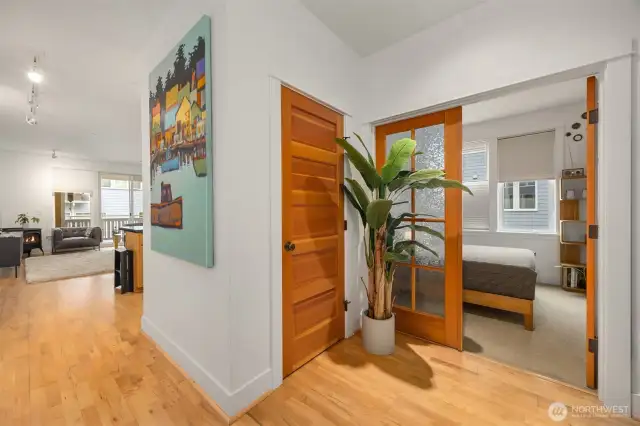View from the front entry to the living room, coat closet and French doors to the second bedroom