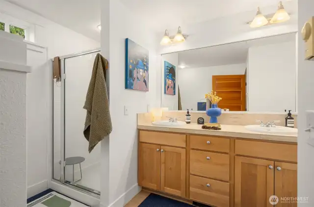 The primary bath with shower, tub, dual vanity with maple cabinet and travertine tile surface. The home also has a second full bathroom.