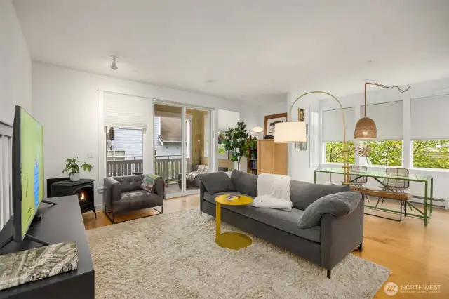 Tall ceilings and windows allow for plenty of natural light. View to the living room, dining room, built-in maple cabinet and slider to the covered balcony.