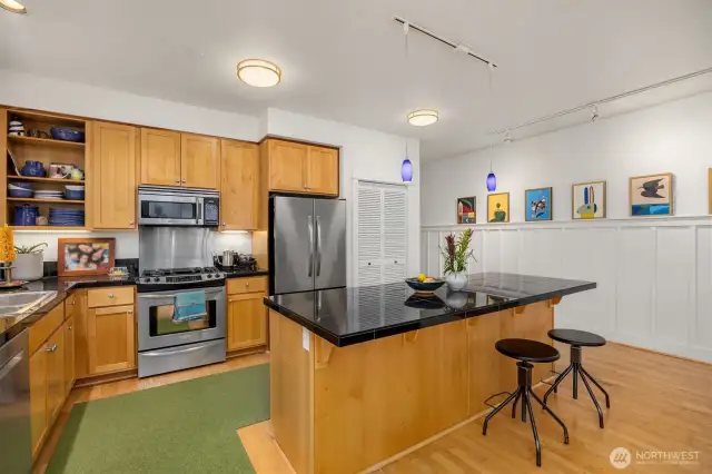 The kitchen is graced with stainless steel appliances, maple cabinets and a breakfast counter.