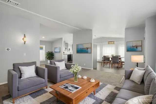 Living room looking toward spacious kitchen and dining room. Flexible floor plan can be set up for many different uses. Virtually staged here.
