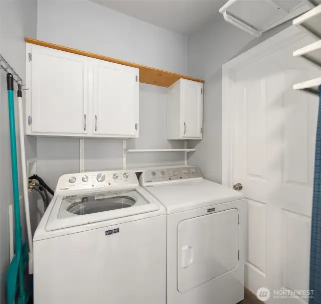 Laundry room with cabinets and storage shelves not shown in photo.
