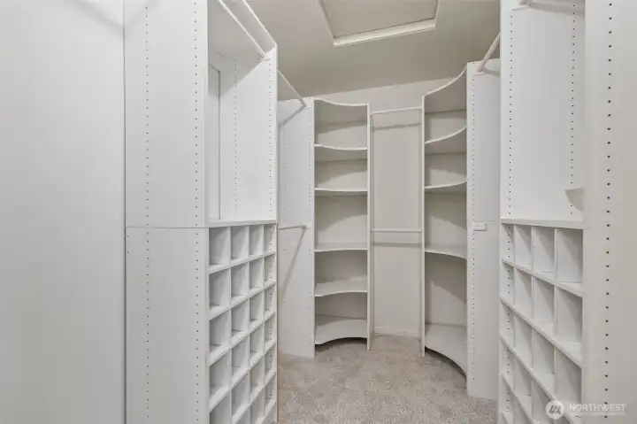 Walk-in closet with installed closet organizer.