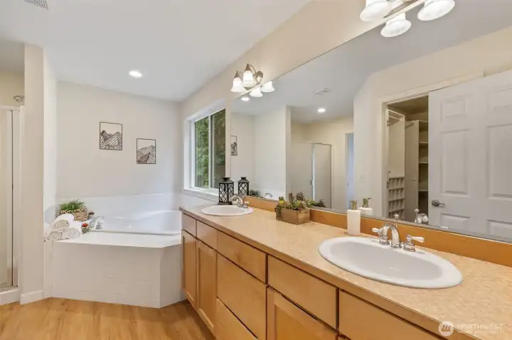 Primary bathroom with dual vanity, corner soaking tub.