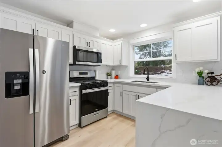 Updated kitchen with beautiful waterfall quartz countertop and newer appliances.
