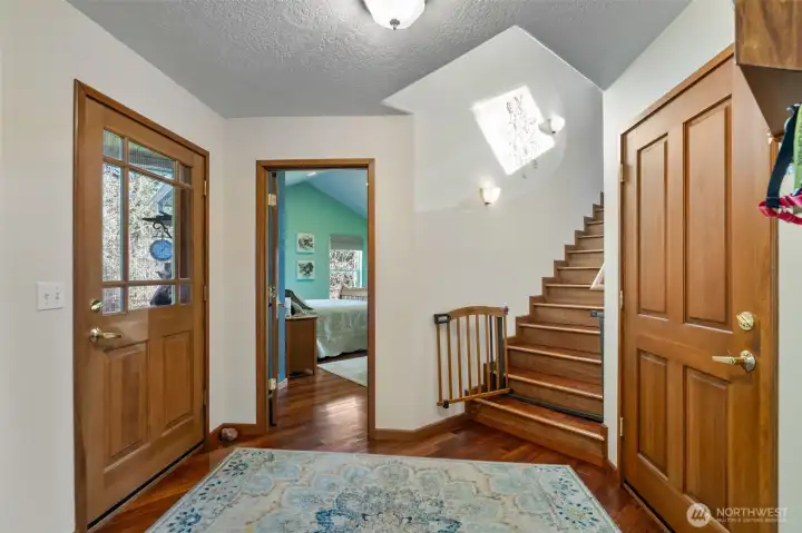 This is one of the doors to the back deck, the primary suite, stairs to bonus room and the way out to the garage. Laundry is also located in the area.