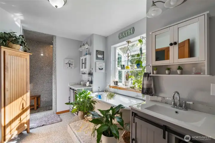 Primary bath has a tiled walk-in shower and a large soaking tub, with separate sinks.