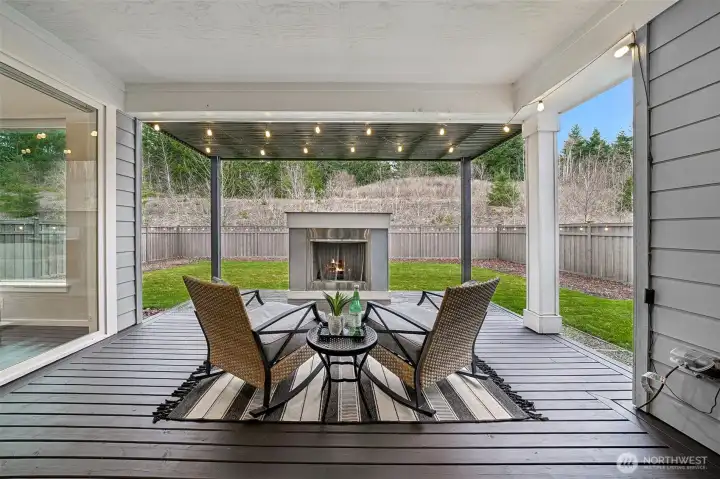 Enjoy the extra large, covered patio with a fireplace and string lights, looking at the beautiful view behind the house
