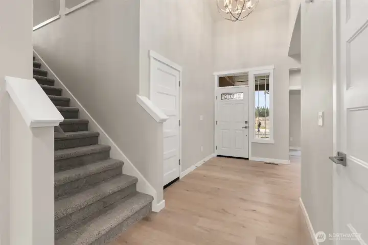 Dramatic entryway greets you with vaulted ceilings and chandelier.