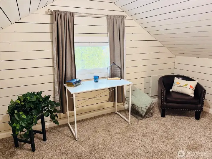 The newly painted upper level offers a bright, clean aesthetic with cozy loft-style charm and added flexibility for office, hobby, or creative use. A striking black attic access detail adds a touch of modern contrast to the inviting space.