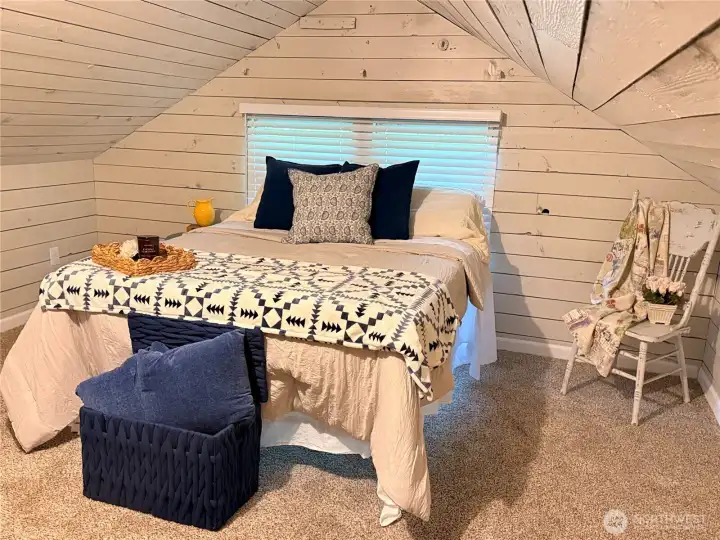The newly painted upper level offers a bright, clean aesthetic with cozy loft-style charm and added flexibility for office, hobby, or creative use. A striking black attic access detail adds a touch of modern contrast to the inviting space.