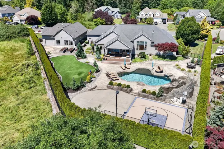Backyard oasis with Astro-Turf play area, resort style pool, sports court & garden areas.