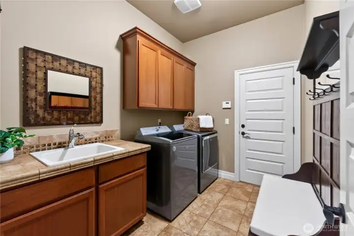 Laundry area off the garage, complete with/utility sink and cabinets.