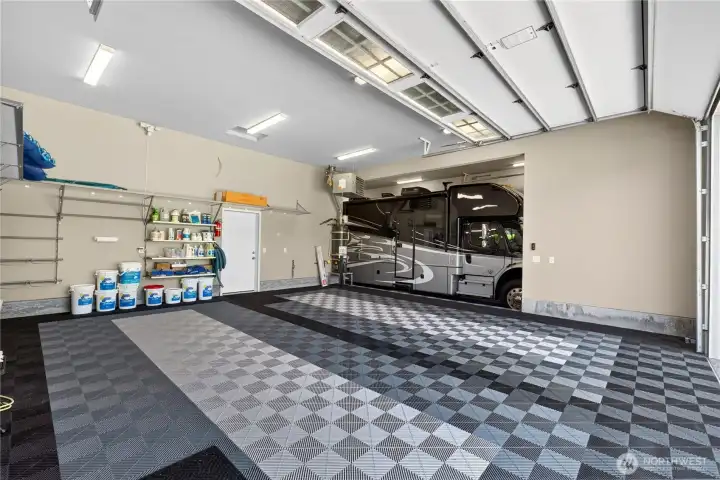 One of the three shop garages. Middle bay is 45 ft long and 14 ft tall, great for RVs.(12x14 ft.) (18x10 ft.)(9x8 ft.)  All with Swiss Trek flooring. Larger doors have commercial openers and smaller has Jackshaft opener.