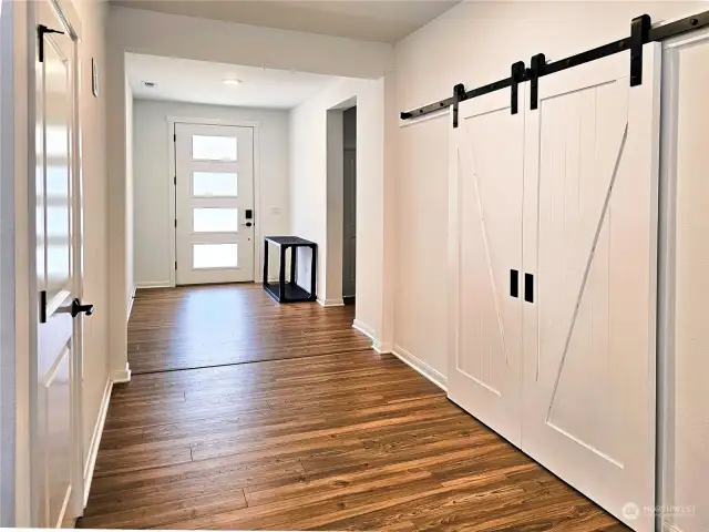 The entryway takes you past the guest bedroom and main floor 3/4 bathroom through the doorway just to the right of the front door. The barn doors lead to the den/office area.