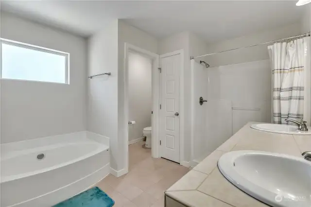 Ensuite Primary 5 Piece Bath, featuring Dual Sinks, Separate Shower and Tub, Private Toilet area, and spacious Walk-In Closet (off photo to the left)